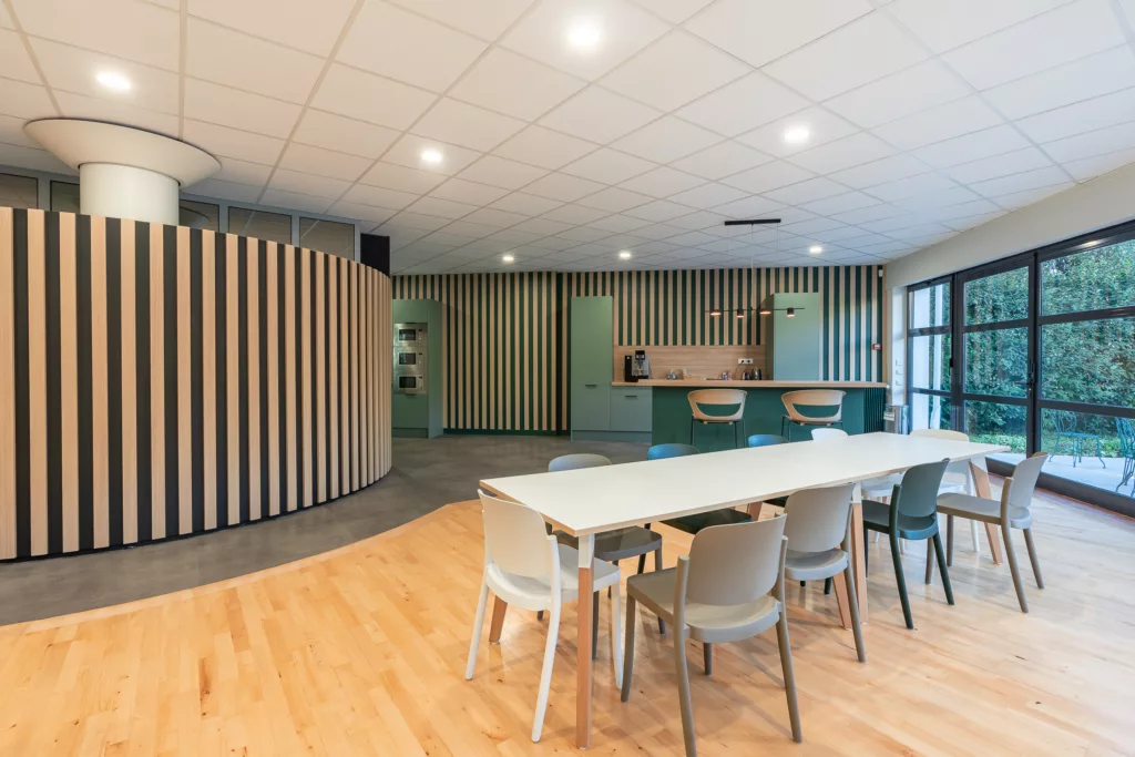 AMSO : Aménagement d'un espace repas/cuisine moderne avec mobilier de cafétéria, plan de travail et décoration murale dans les bureaux au Perray en Yvelines (78).