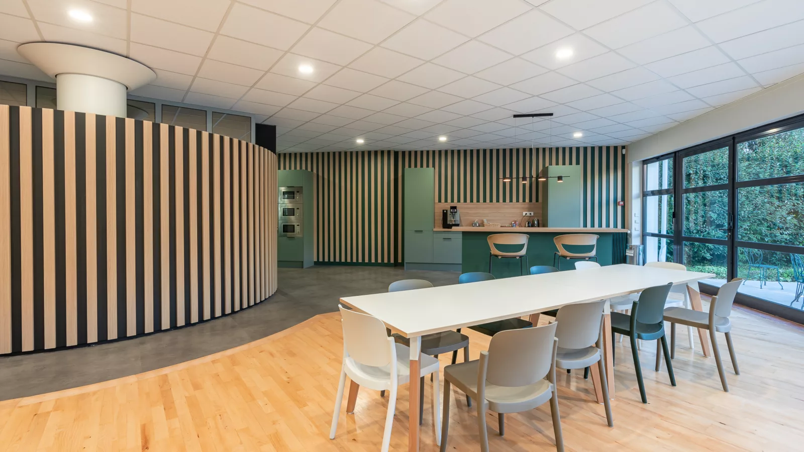 AMSO : Aménagement d'un espace repas/cuisine moderne avec mobilier de cafétéria, plan de travail et décoration murale dans les bureaux au Perray en Yvelines (78).