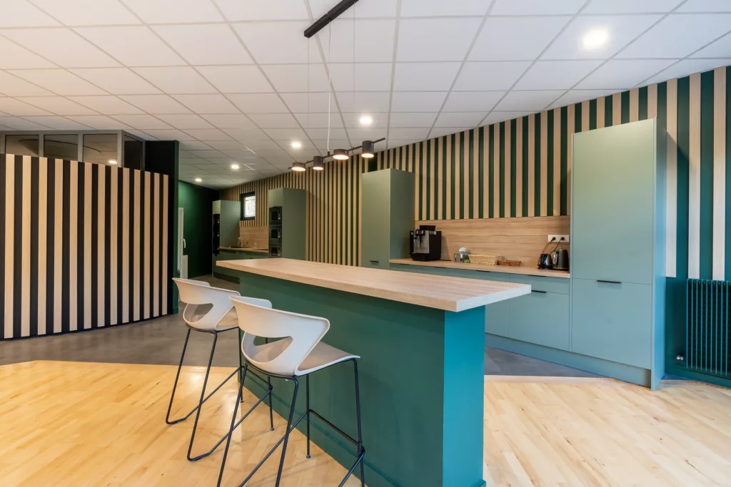 AMSO : Aménagement d'un espace repas/cuisine moderne avec mobilier de cafétéria, plan de travail et décoration murale dans les bureaux au Perray en Yvelines (78).
