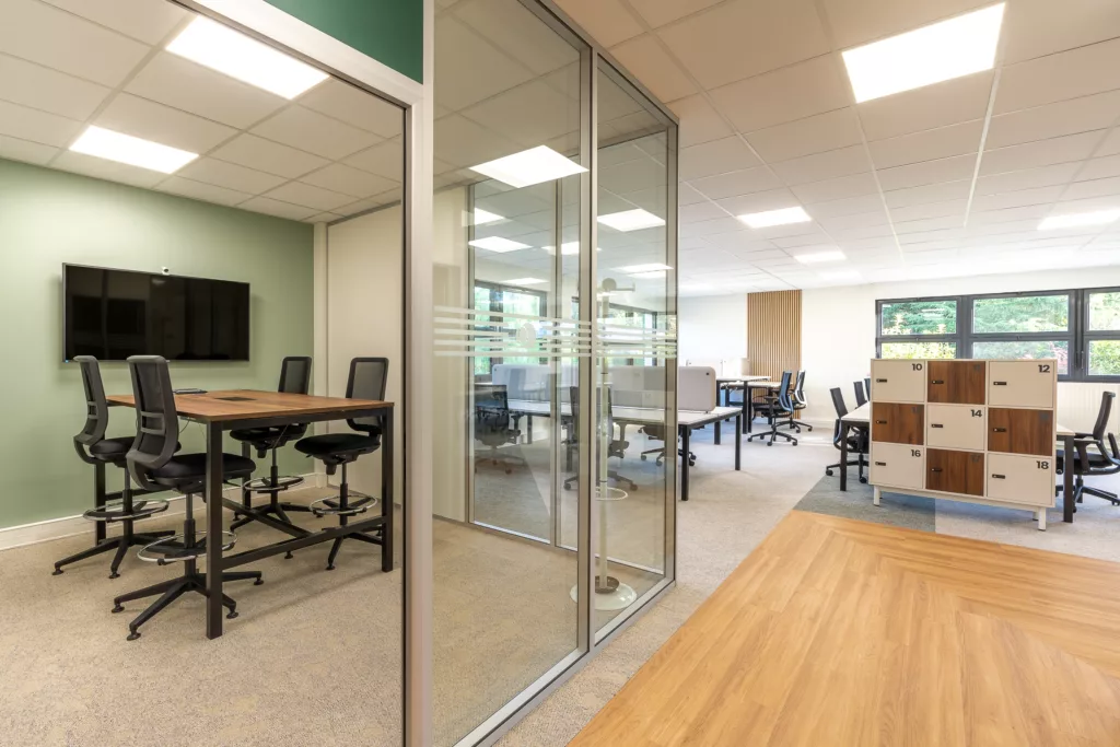 Aménagement d'une salle de réunion fermée par une cloison amovible vitrée et équipée d'un écran de présentation dans les bureaux au Perray en Yvelines (78).