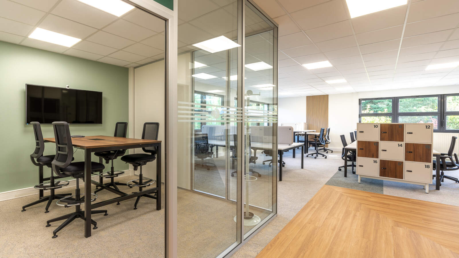 Aménagement d'une salle de réunion fermée par une cloison amovible vitrée et équipée d'un écran de présentation dans les bureaux au Perray en Yvelines (78).