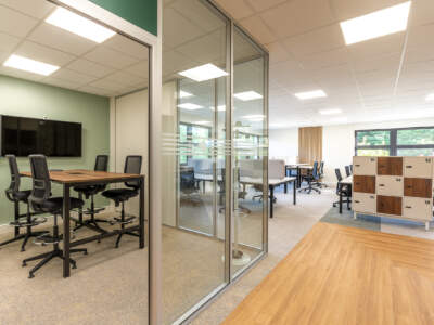 Aménagement d'une salle de réunion fermée par une cloison amovible vitrée et équipée d'un écran de présentation dans les bureaux au Perray en Yvelines (78).