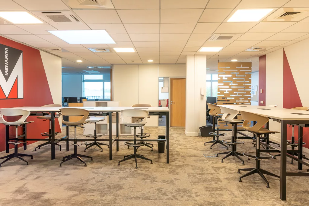 AMSO : Aménagement d'une salle de collaboration moderne avec mobilier professionnel, revêtement de sol neuf et visuel mural (Menarini) pour les bureaux de Rungis.