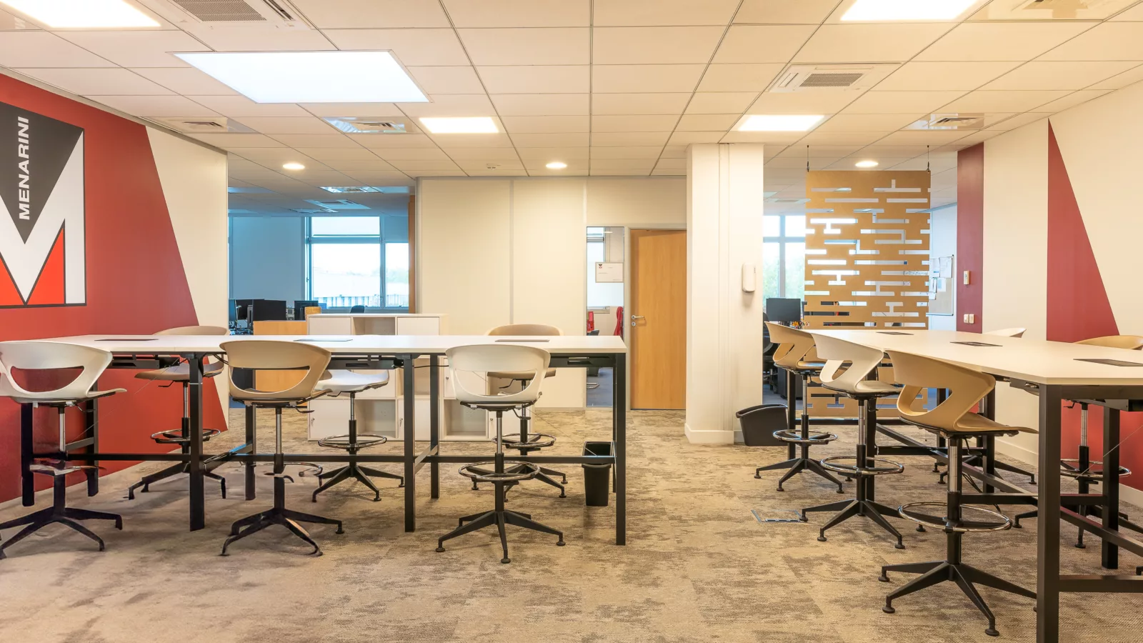 AMSO : Aménagement d'une salle de collaboration moderne avec mobilier professionnel, revêtement de sol neuf et visuel mural (Menarini) pour les bureaux de Rungis.