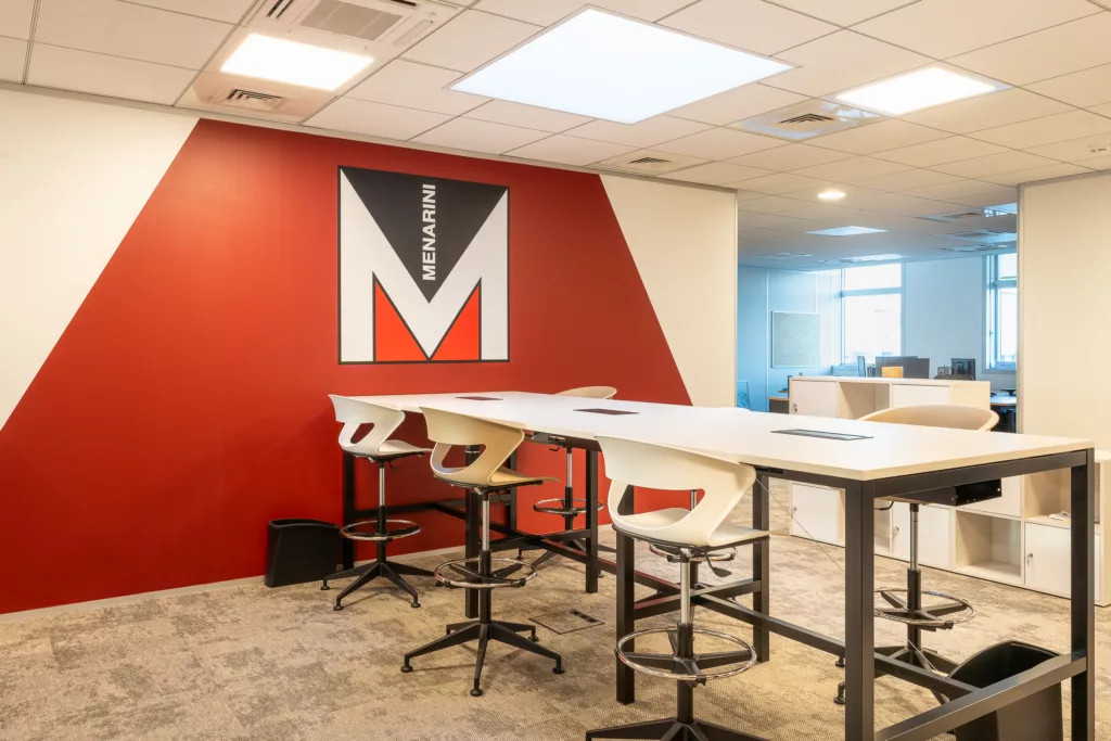 AMSO : Aménagement de bureaux avec cloisons vitrées personnalisées (logo Menarini) et séparation design pour un espace collaboratif à Rungis 94.