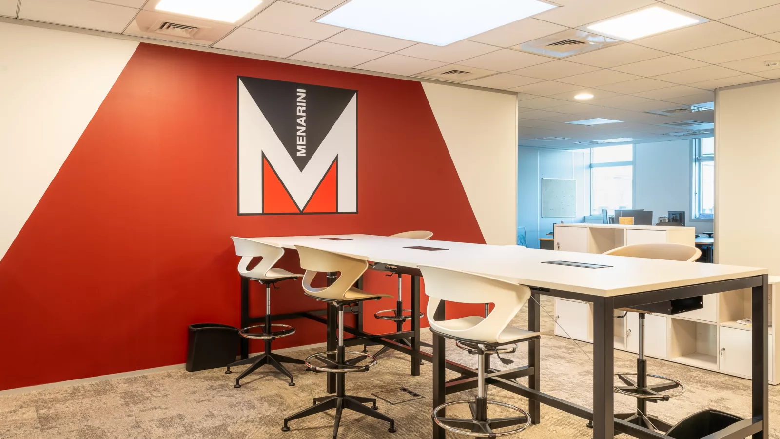 AMSO : Aménagement de bureaux avec cloisons vitrées personnalisées (logo Menarini) et séparation design pour un espace collaboratif à Rungis 94.
