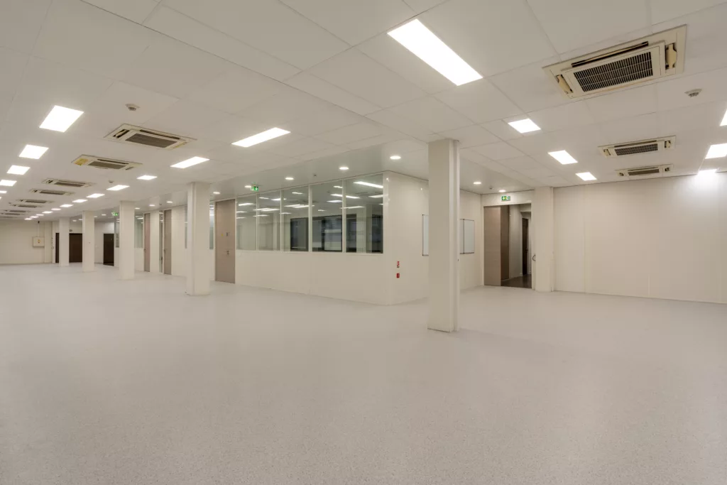 Rénovation d'un plateau de bureaux vide (open space) pour NCS System à Élancourt (78). Installation de dalles de faux plafond, ventilation et pose de sol technique.