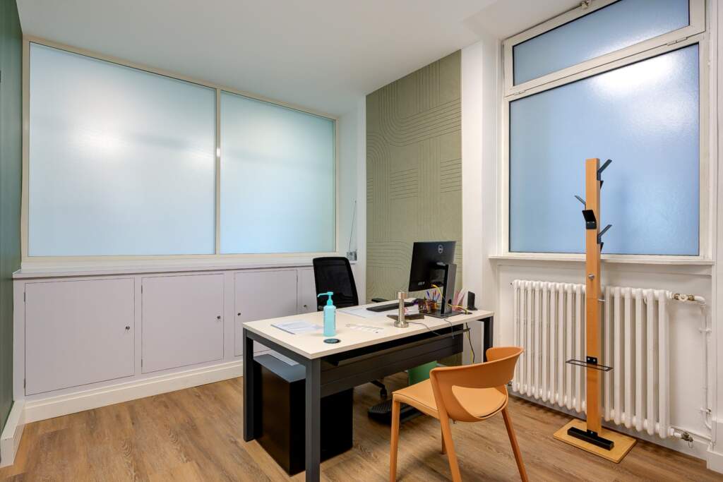 Bureau de consultation médicale rénové par AMSO à Paris. Aménagement incluant un panneau acoustique décoratif mural, du mobilier professionnel ergonomique et un sol PVC imitation parquet
