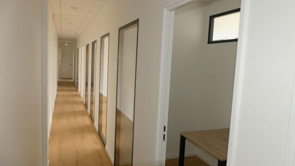 Aménagement d'un open space lumineux avec bureaux ergonomiques et solutions d'isolation acoustique pour collaborateurs.