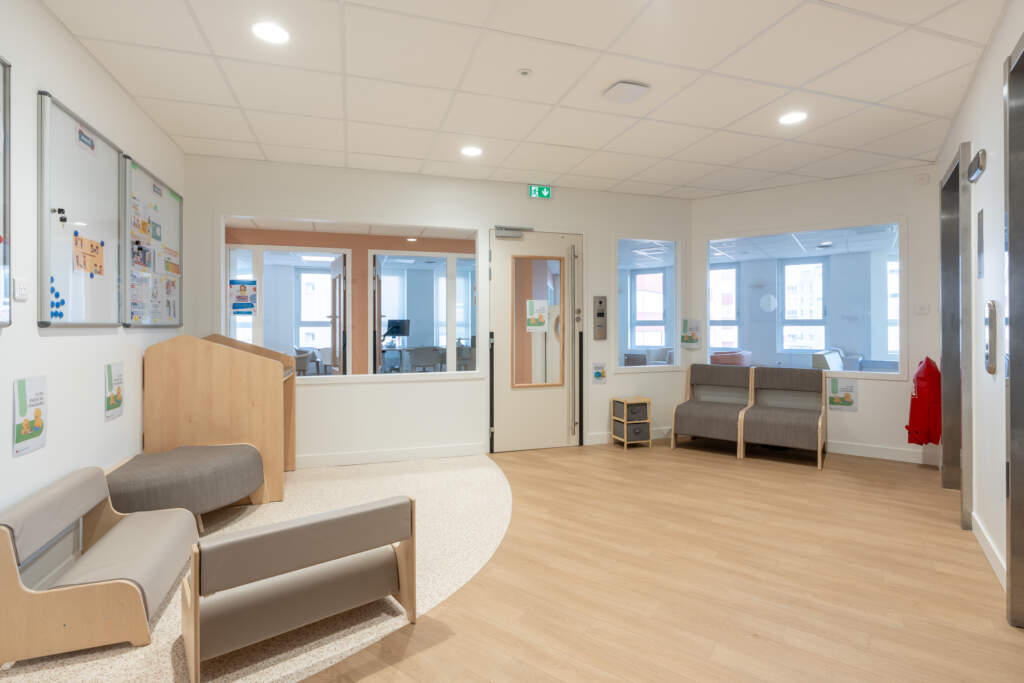 Zone d'accueil accessible ERP avec mobilier ergonomique et sol souple bois.