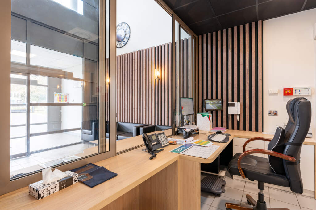Bureau d'accueil avec cloison vitrée et espace dégagé adapté pour l'accessibilité des locaux professionnels.