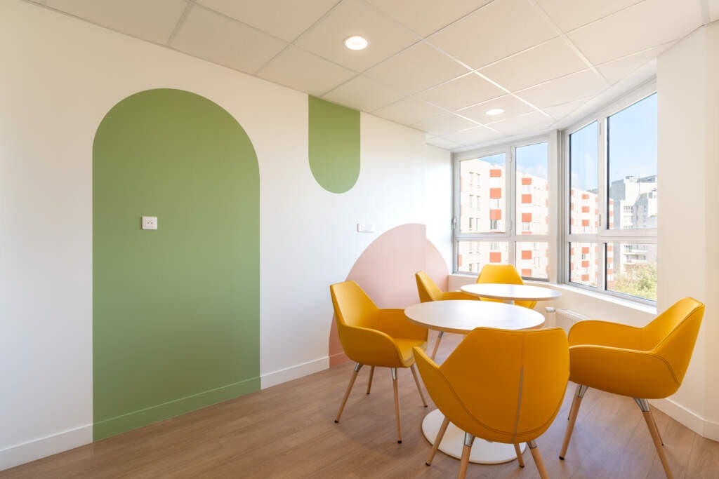 Salle de motricité avec matériel de psychomotricité et sol amortissant.