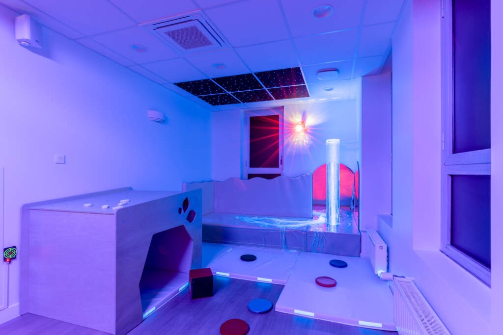Aménagement salle Snoezelen avec colonne à bulles et éclairage fibre optique.