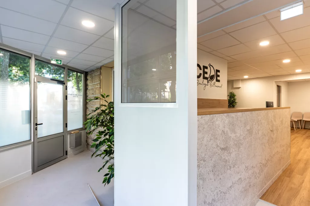 Sas d'entrée vitré menant vers la banque d'accueil d'un pôle de santé moderne à Boulogne-Billancourt.