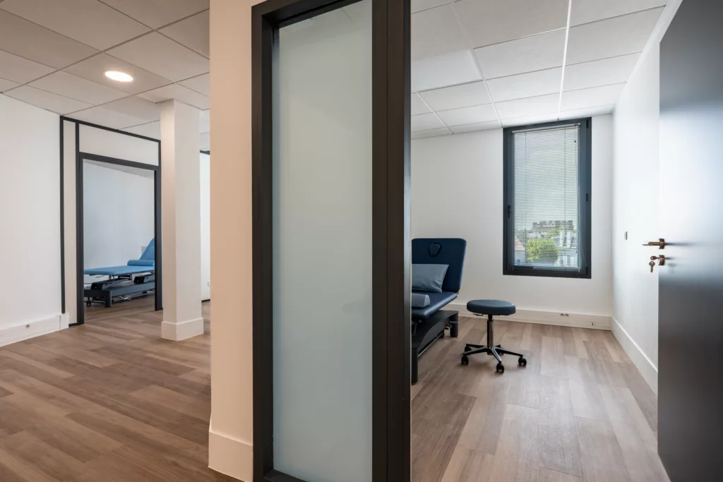 Salle de consultation médicale rénovée avec cloisonnette de confidentialité vitrée sablée.